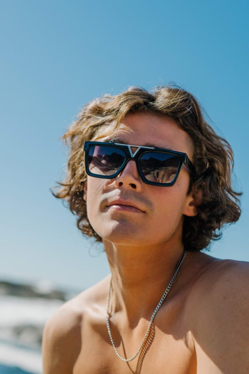 Modelo llevando las gafas de sol para hombre Dorelion Axis negras y plateadas con lentes negras polarizadas y protección UV400.