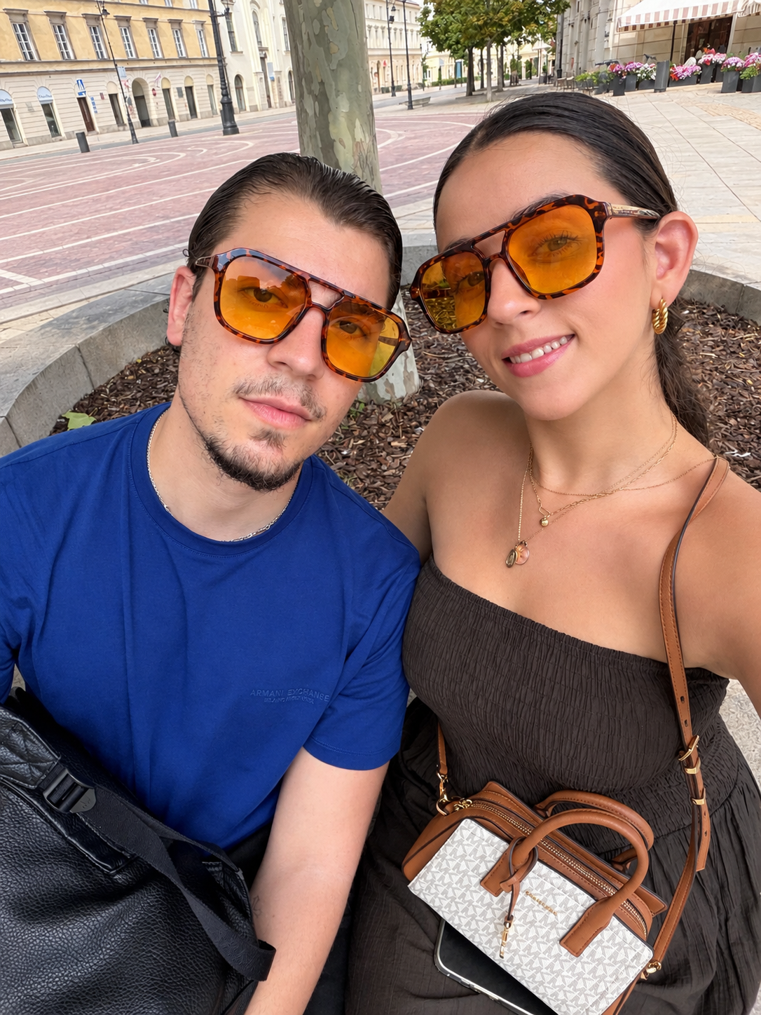 Pareja con gafas de sol de lentes ámbar en una plaza