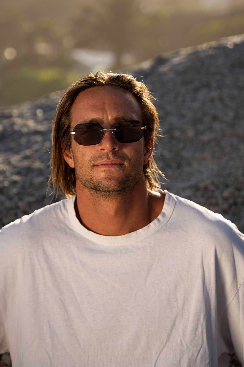 Modelo llevando las gafas de sol de metal para hombre Dorelion Alco doradas con lentes polarizadas y protección UV400.