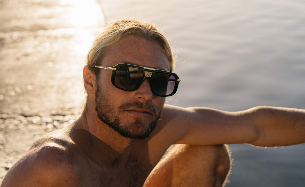 Modelo llevando las gafas de sol para hombre Dorelion Mira negras y doradas con lentes polarizadas y protección UV400.