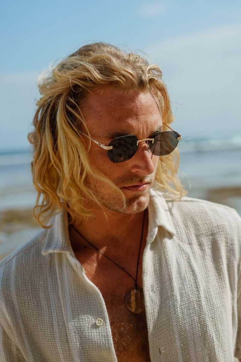 Modelo llevando las gafas de sol para hombre Dorelion Orion con montura metálica dorada, lentes polarizadas y protección UV400.