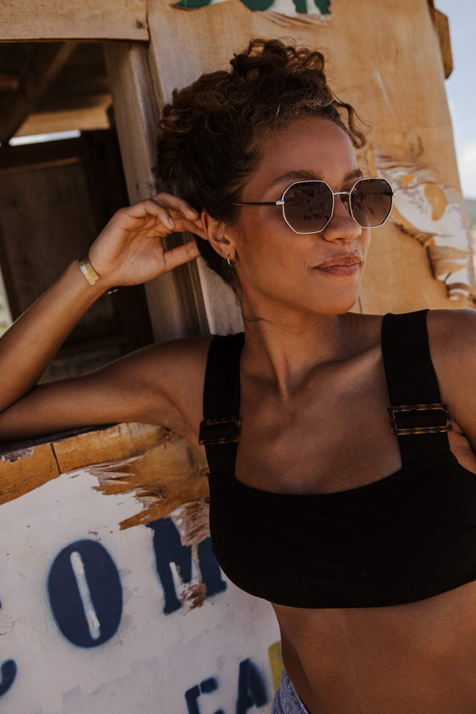 Modelo llevando las gafas de sol para mujer Dorelion Aura con montura plateada y detalles en color cobre, lentes negras polarizadas y protección UV400.